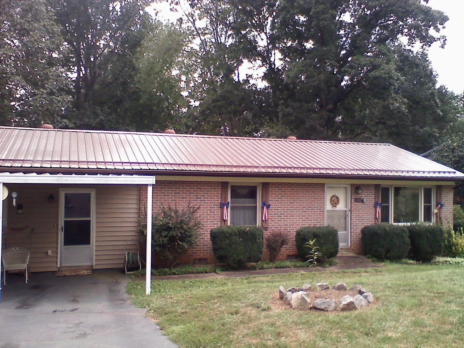 Bronze metal roof and carport on a brick ranch home — Roof Repair work by our crew in Granite